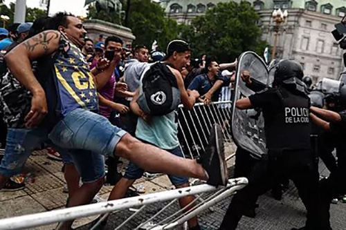 بالصور.. العاصمة الأرجنتينية تشهد اشتباكات أثناء مراسم وداع مارادونا