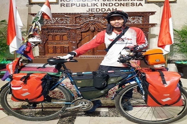 إندونيسي يقود دراجة هوائية لأداء فريضة الحج