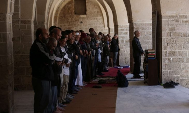 بالصور: فلسطينيون يؤدون الصلاة على أنقاض المسجد الكبير في غزة